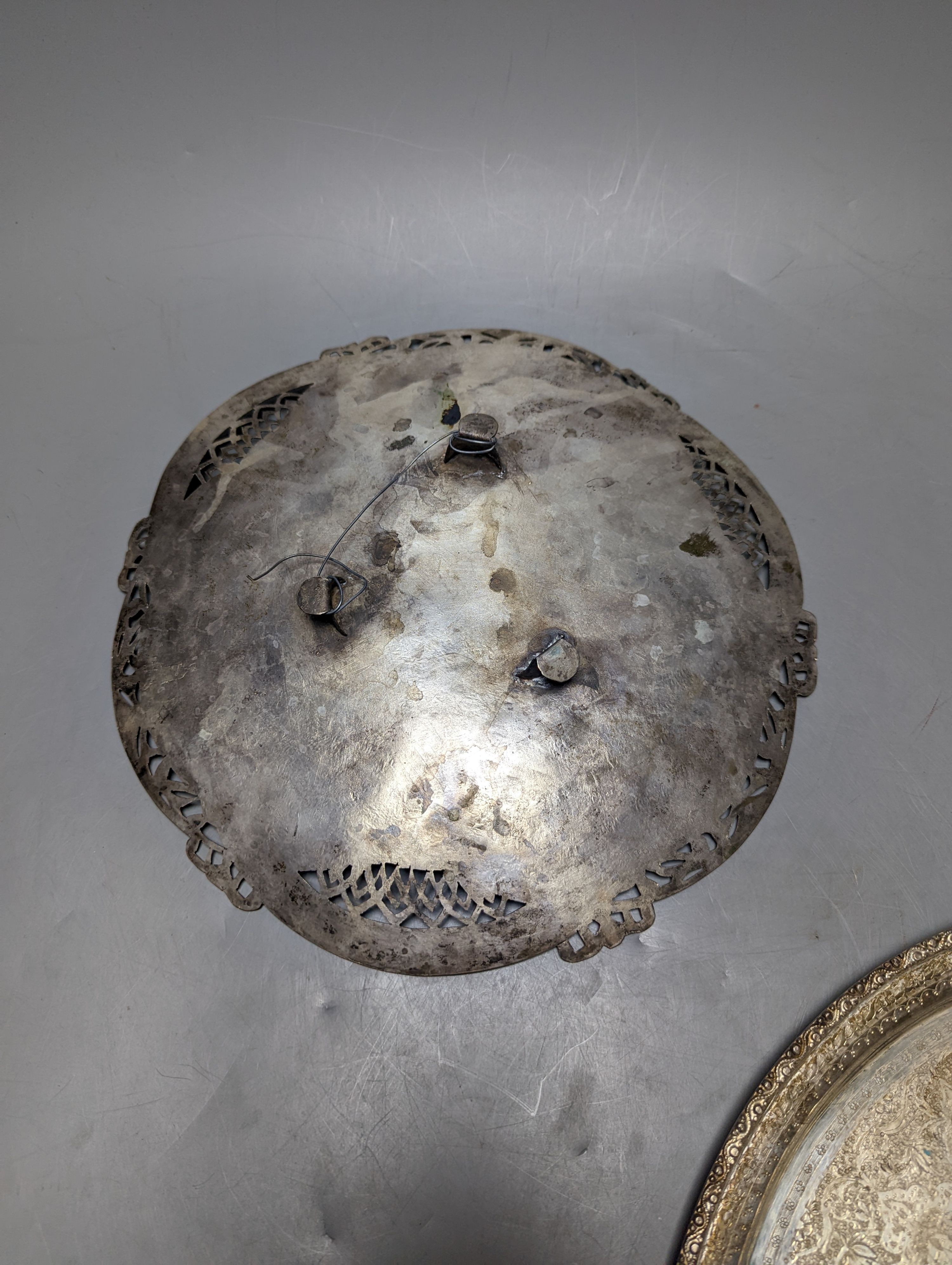 A Persian engraved white metal circular drink's tray by Vartan, 32cm, 747 grams and a white metal wall plaque.